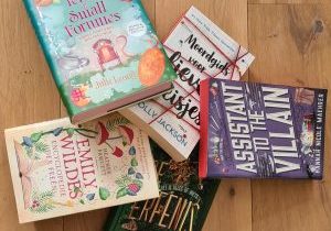 Serie? Ik dacht dat het een standalone was! 5 boeken op een houten vloer.